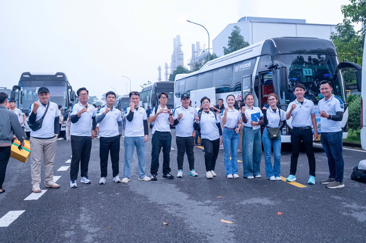 Đội ngũ nhân viên tập trung cạnh xe đưa đón company trip